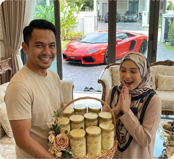Pasangan memegang bakul hamper tin CEO Bakes dan kereta merah